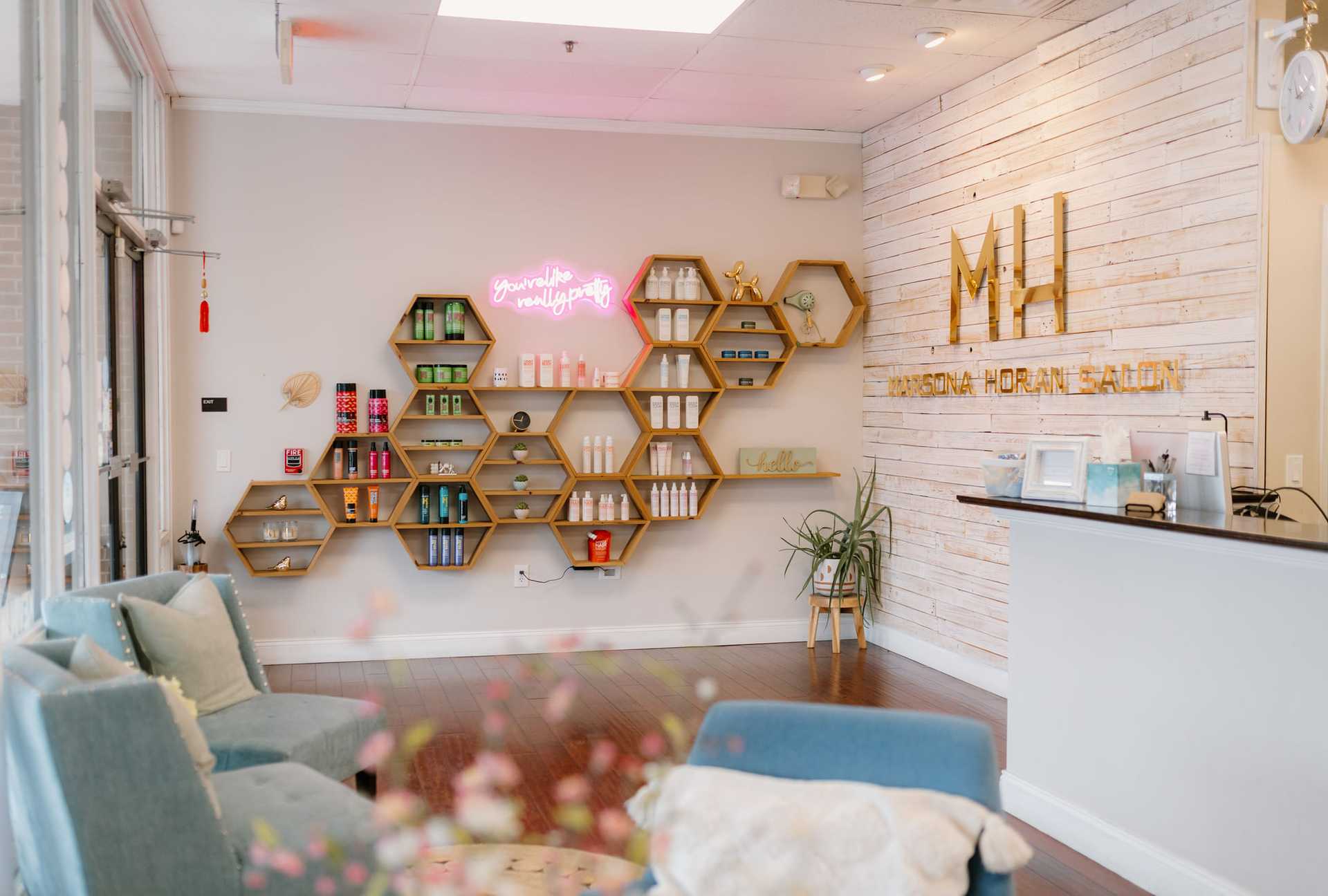 Modern salon interior with hexagonal shelves and a welcoming seating area.